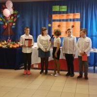 Uczniowie klasy 5 występują przed publicznością szkolną.