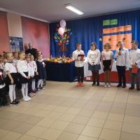 Uczniowie klasy 5 występują przed publicznością szkolną.