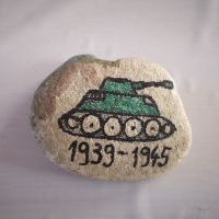 Kamień z namalowanym zielonym czołgiem, pod którym znajduje się data: 1939 - 1945.